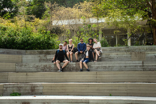 Group of friends in sportswear posing on outdoor bleachers 