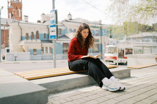 Portrait of young brunette woman sitting outdoors
