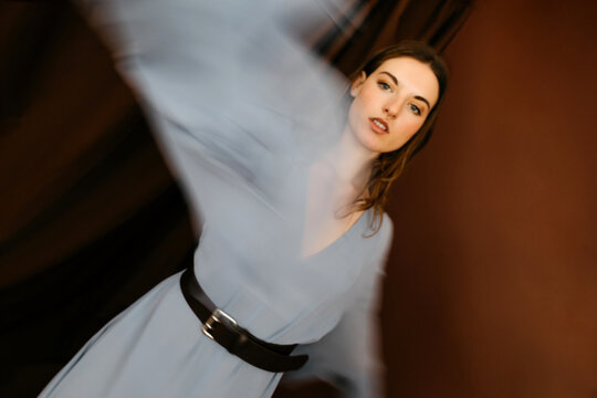 Fashion model wearing blue dress with motion blur effect
