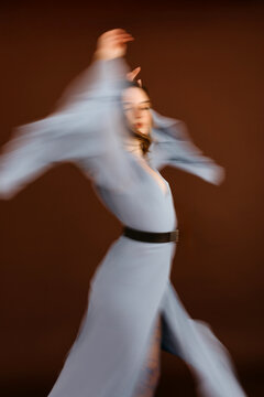 Studio shot of a fashion model dancing with a blurred motion effect