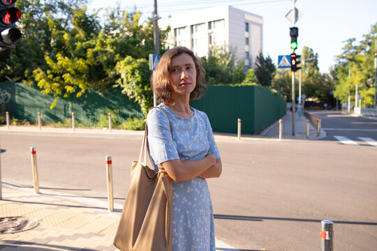a woman in a dress walks in the city