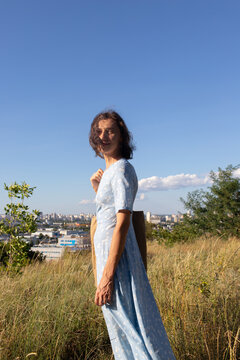 a woman in a dress walks in the field