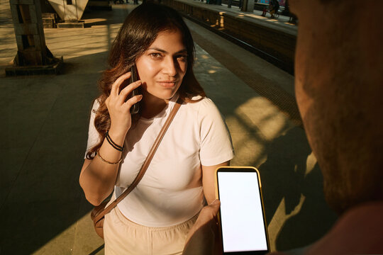 Woman on a phone call at a train platform in Mumbai