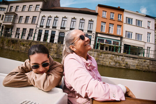 Woman enjoying a boat ride while companion rests