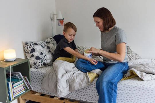 Mom applying eczema cream on her son
