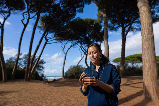 asian woman under pine trees