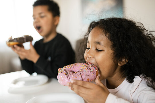 Kids Enjoying Colorful Donuts Together at Home