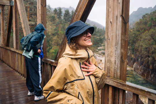 Happy woman on a wooden bridge in the rain