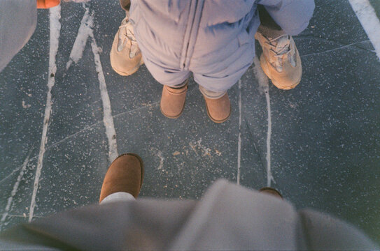 Unrecognizable Family Feet on Frozen Cracked lake backdrop - film 