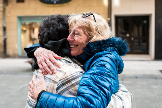 Happy senior mother hugging adult son 