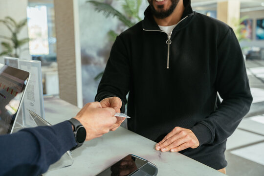 Hotel receptionist giving keycard to guest during check-in process