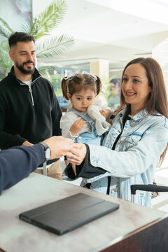 Family receiving key card from receptionist in hotel lobby