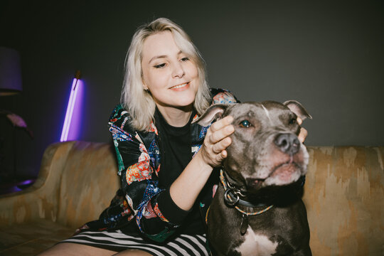 Woman Affectionately Petting Dog on Couch