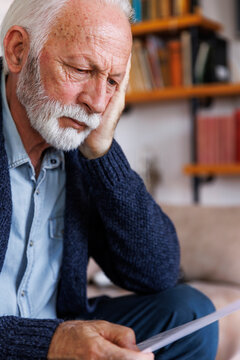 Serious man sitting and reading paper