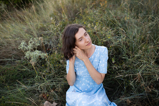 a woman is sitting on the grass