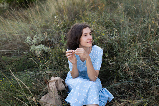 a woman is sitting on the grass