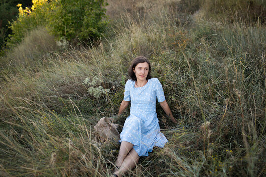 a woman is sitting on the grass