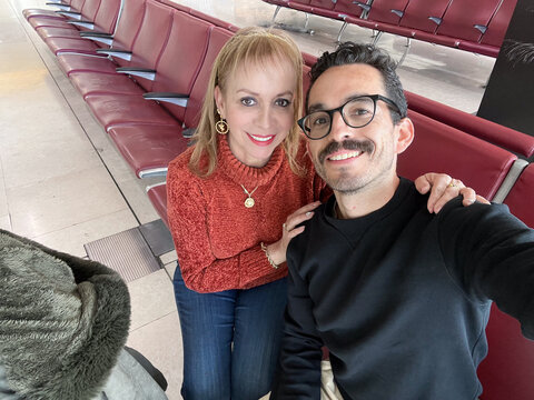 Mom and son smiles at the airport waiting area together