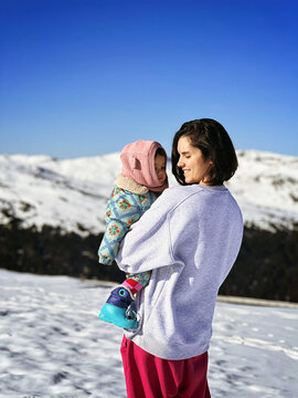 Mother and Child Enjoying a Snowy Mountain Day