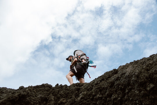 Father Hikes With Son on Volcanic Rocks