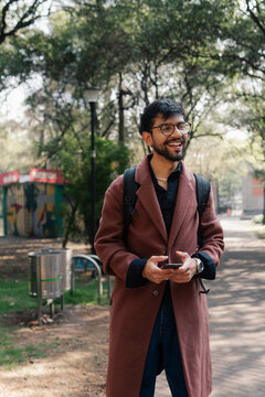 A man with an amused and distracted expression while walking.
