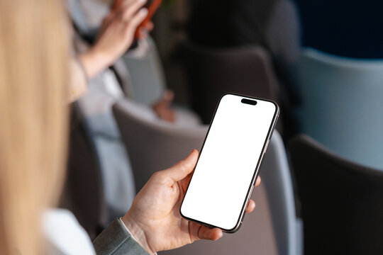 A woman uses a mobile phone with white screen
