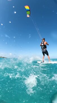 Man Kiteboarding on Turquoise Water Under a Bright Blue Sky Engaging in Extreme Water Sport Action