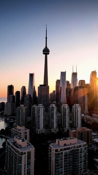 Towering Cityscape At Dusk With Orange Sunset Hues Overlooking Water And Condominiums