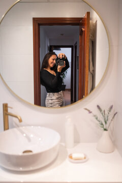 Photographer taking a selfie in her bathroom at home
