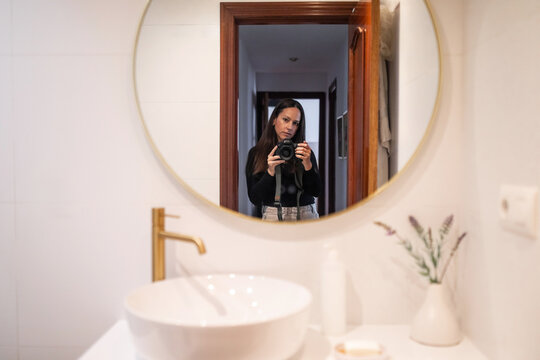 Photographer taking a selfie in her bathroom at home
