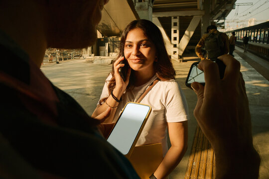 Woman talking on the phone at a train station in Bombay