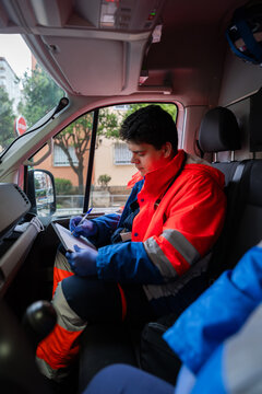 Paramedic writing medical report inside ambulance