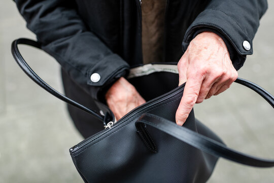 Senior hands opening handbag