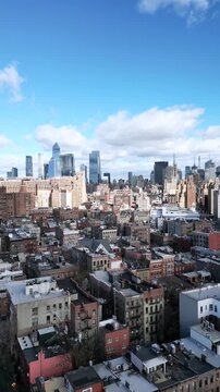 Impressive aerial view of the greenwich village neighborhood with the lower manhattan skyline in the background on a sunny day with clouds, a unique perspective of new york city urban life