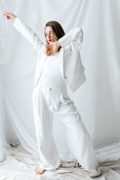 Stylish female dancer performing in white suit 