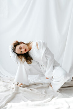 Model posing in white outfit on white background