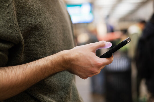 Anonymous Man using Cell Phone in Subway Stop