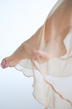Flowing fabric covering feet, showcasing delicate textures 