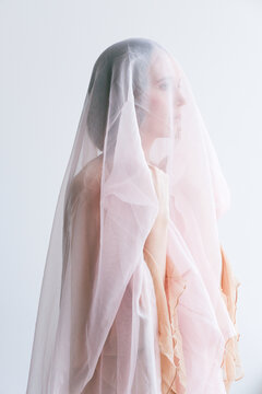 Ethereal portrait of a woman draped in sheer fabric against
