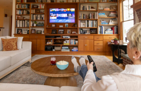 Senior citizen watch tv at home entertainment center 
