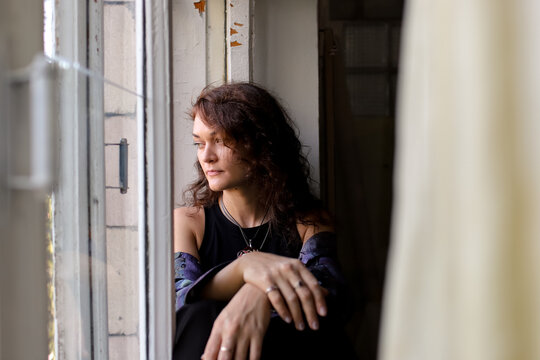 A woman sits on a windowsill in the studio.