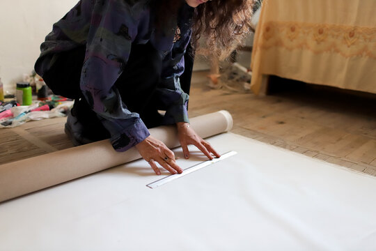 female artist cutting paper in studio