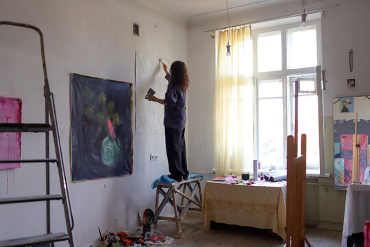 Female artist painting a picture in the studio