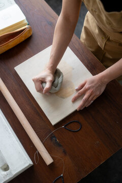 anonymous woman Sculpting Clay on Wooden Board