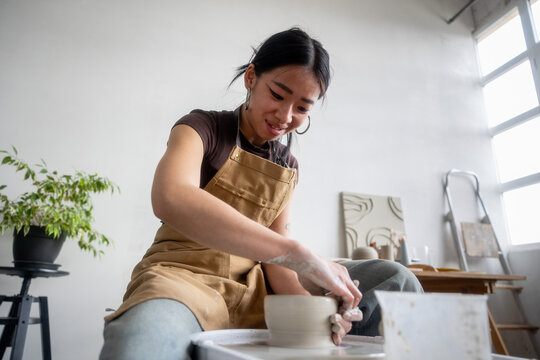 Young Ceramic Artist Working Enthusiastically in a Bright Pottery Stud