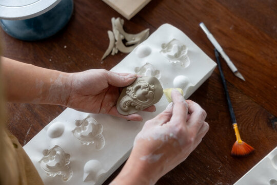 Detail of the hands of a ceramist refining a piece of ceramic