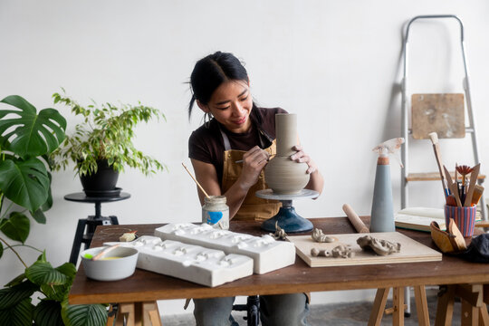happy Pottery Artist Sculpting Clay Vase in a Studio