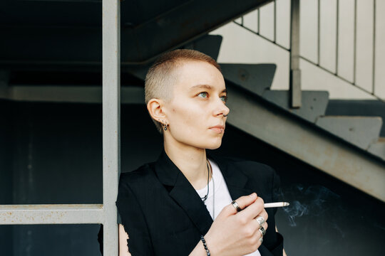 cool woman with short hair smoking outdoors