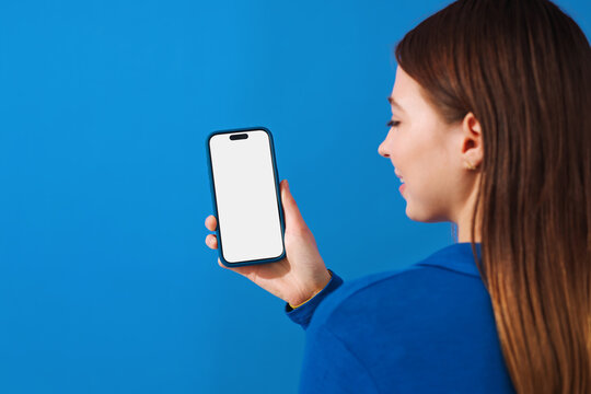 Mockup phone with white screen. Woman Holding Phone on blue background