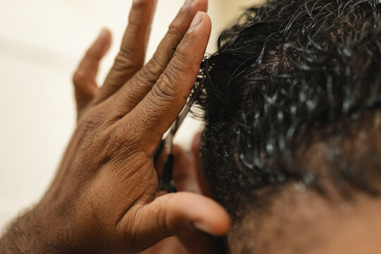Close-up hand holding scissors cutting hair